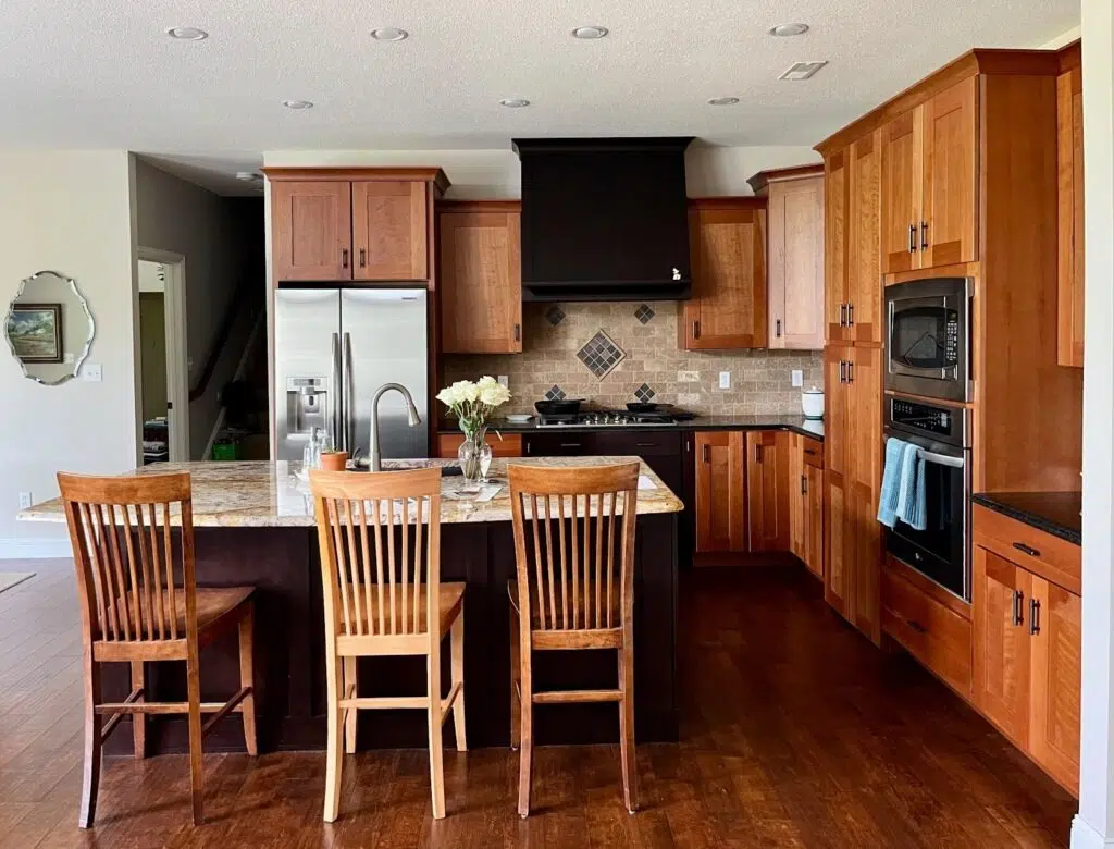 A kitchen features SW Natural Linen kitchen walls with dark wood cabinets.