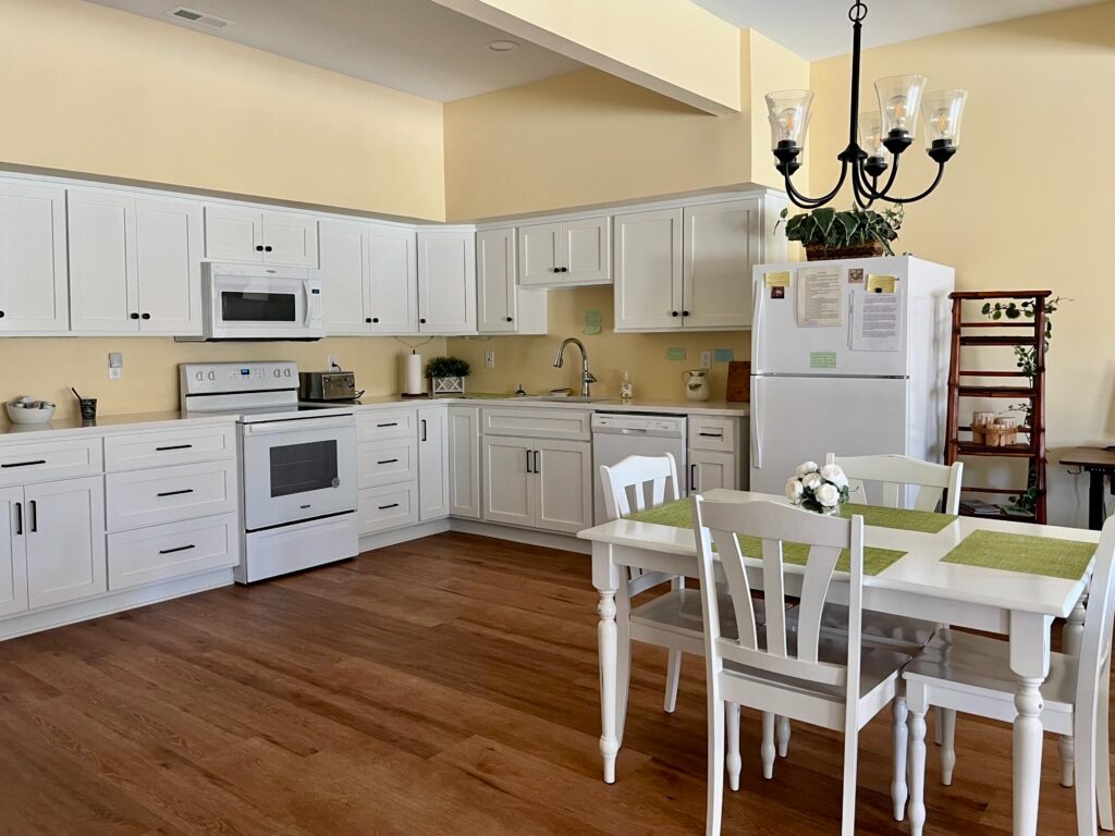 A kitchen features BM Cornsilk wall paint with Oxford White cabinets.