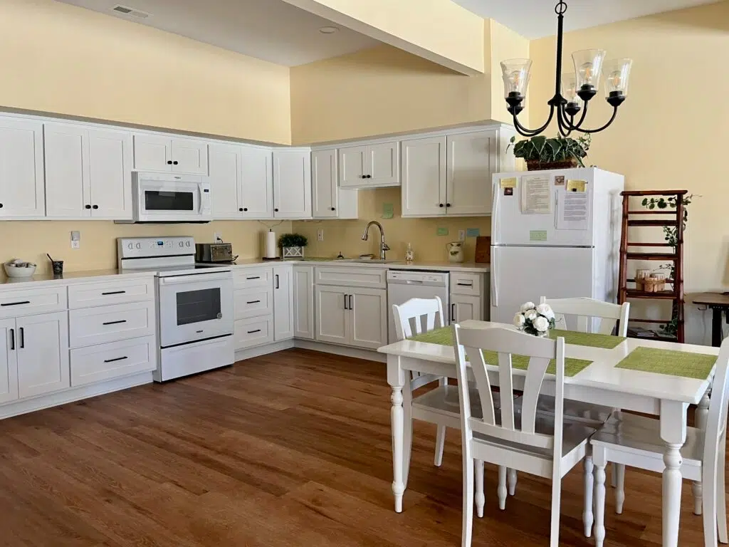 A kitchen features BM Cornsilk wall paint with Oxford White cabinets.
