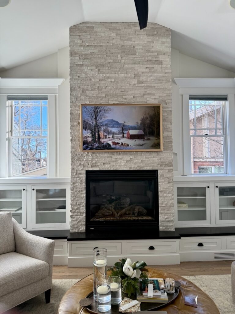 A living rom with fireplace and built-ins features Benjamin Moore Dove Wing walls.