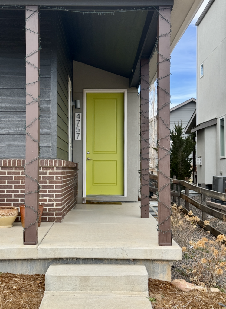 A home features front columns painted with Sherwin-Williams Brevity Brown solid stain.