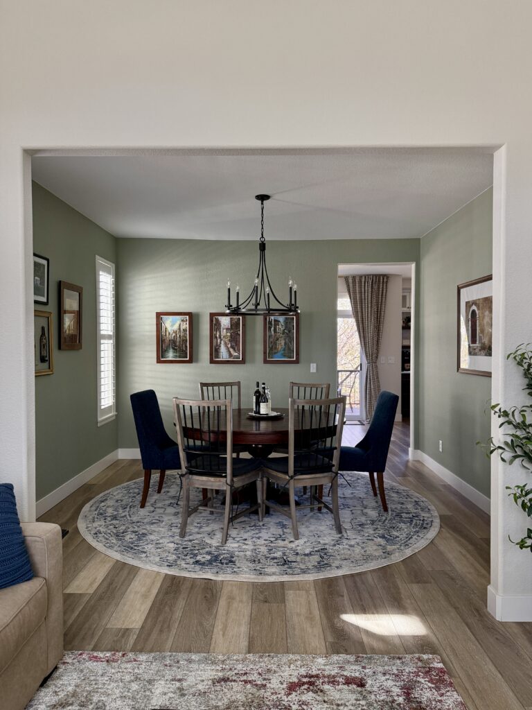 A dining room painted with Benjamin Moore Saybrook Sage alongside BM Ballet White walls.