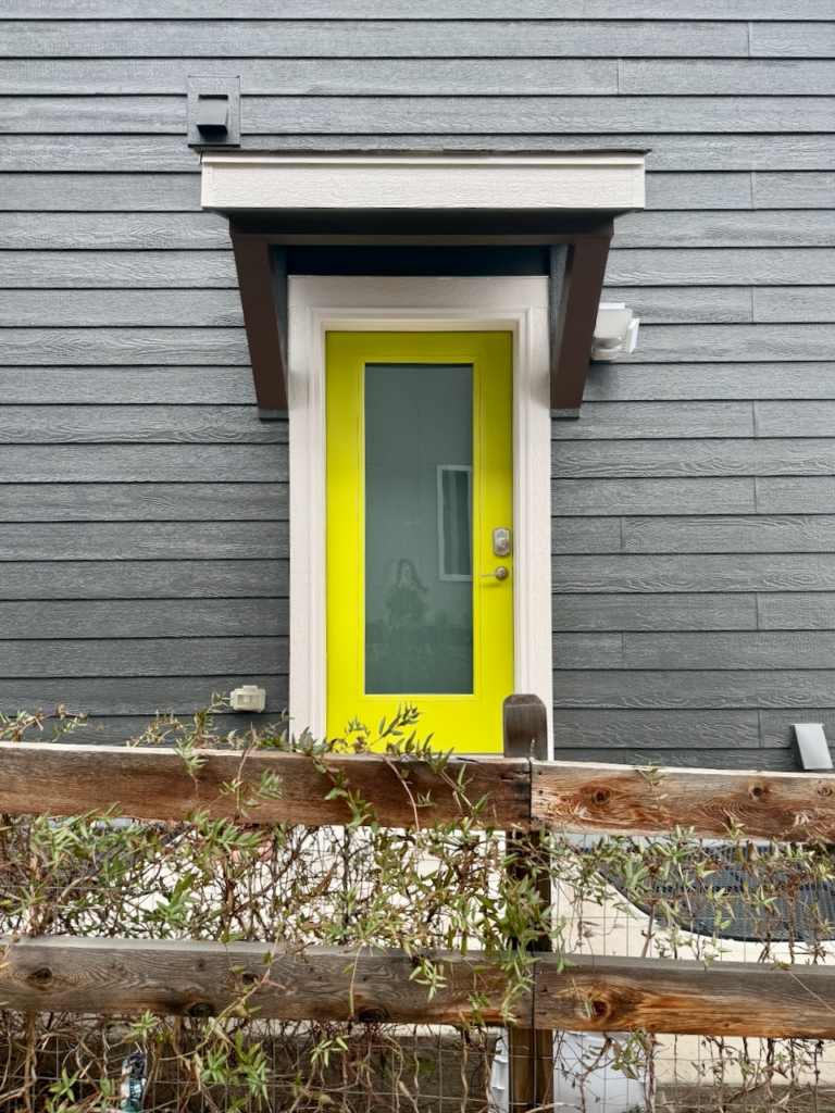 An exterior door painted with Sherwin-Williams Hep Green, pictured alongside SW Iron Ore siding.