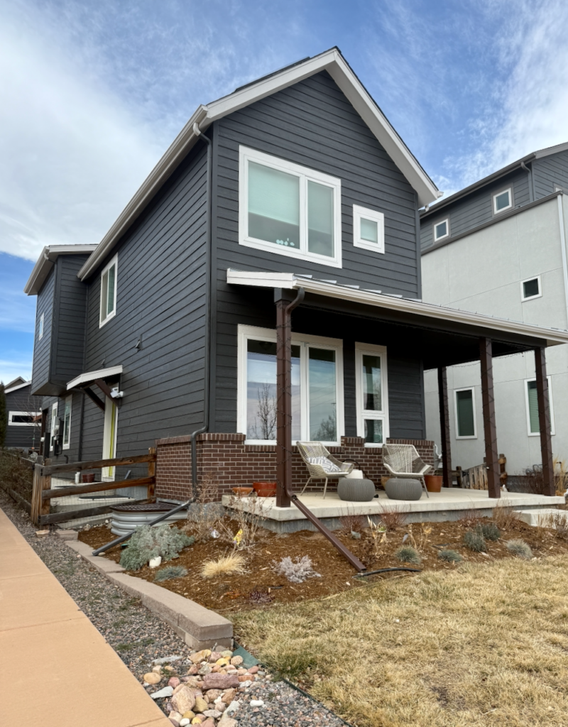 A home features Sherwin-Williams Iron Ore exterior paint siding, SW Egret White trim and red brick accent.