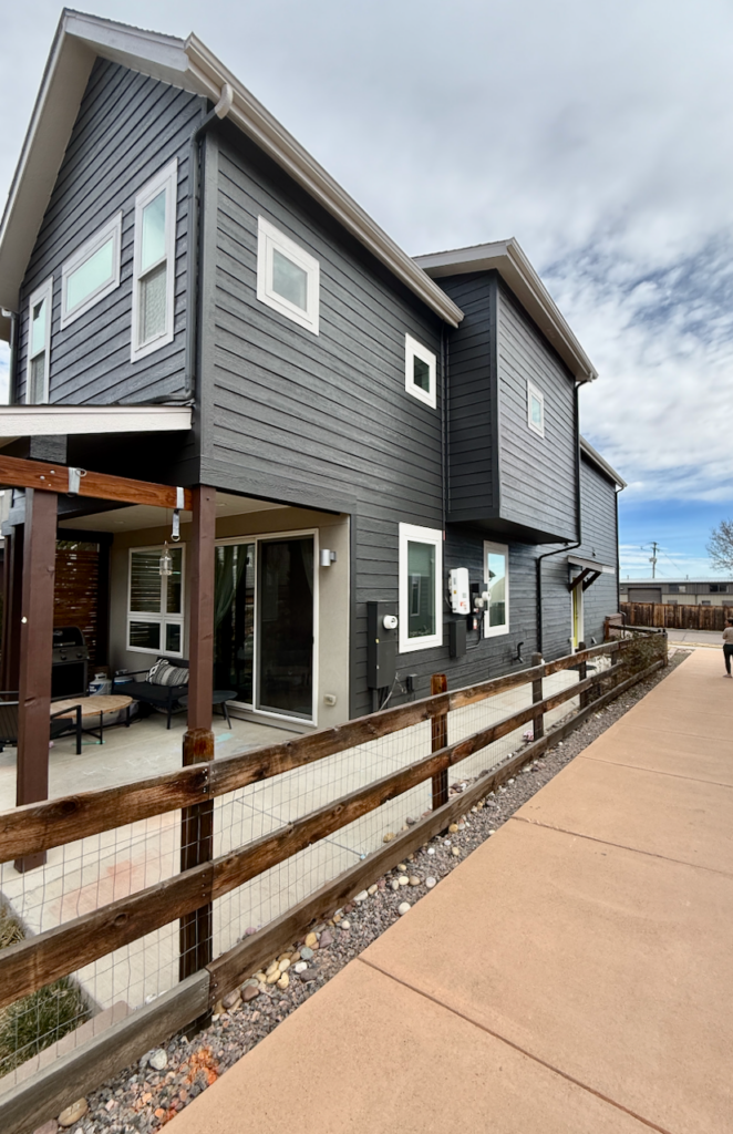 A home features SW Iron Ore exterior paint with SW Egret White trim, including on the downspouts and gutters.