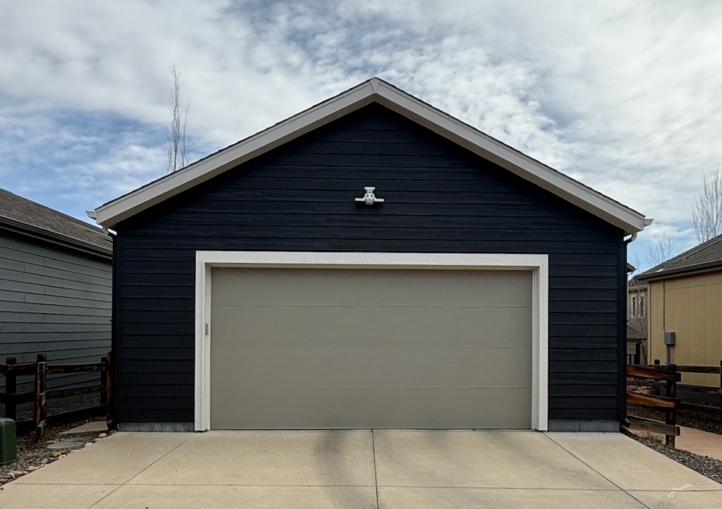 A garage door is painted with SW Intellectual Gray and SW Iron Ore siding.