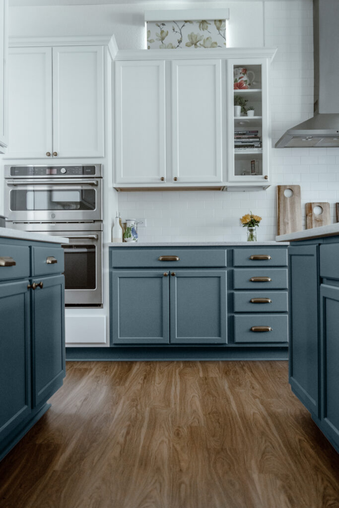 A kitchen featuring white upper cabinets and Sherwin-Williams Blustery Sky lower cabinets.