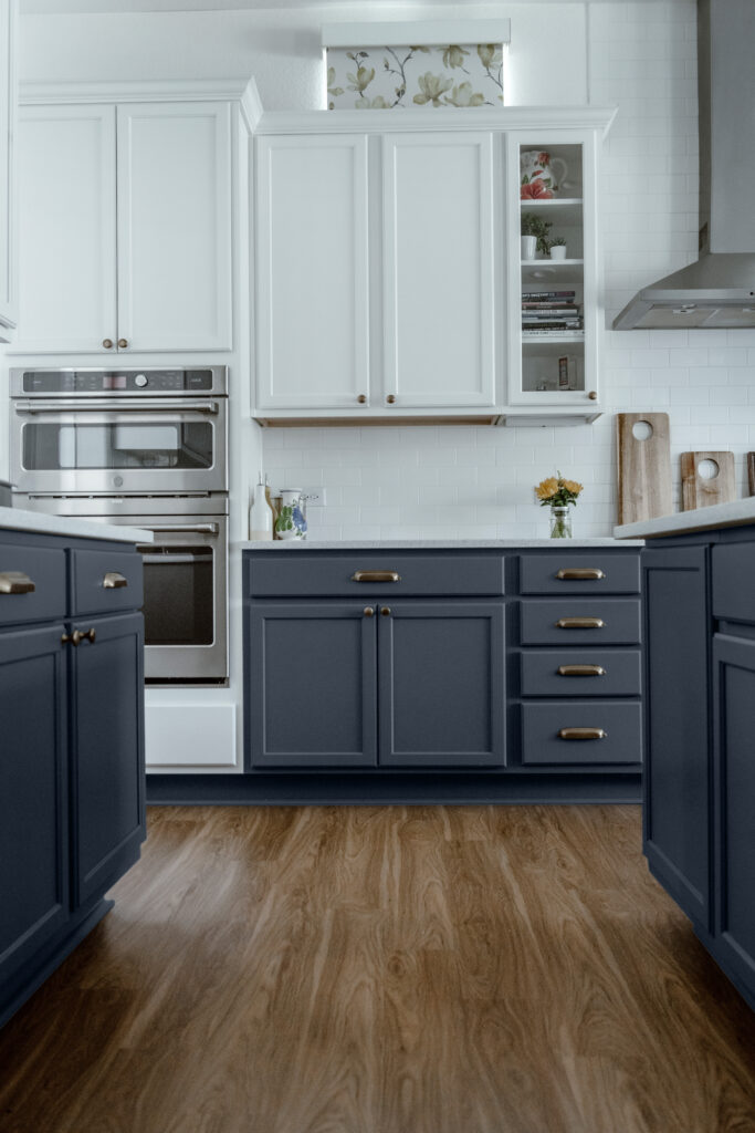 A kitchen featuring white upper cabinets and Benjamin Moore Hale Navy lower cabinets.