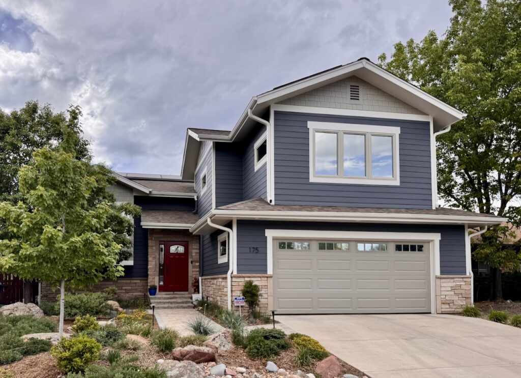 A front door is painted with SW Sun Dried Tomato exterior paint to complement the SW Grays Harbor siding.