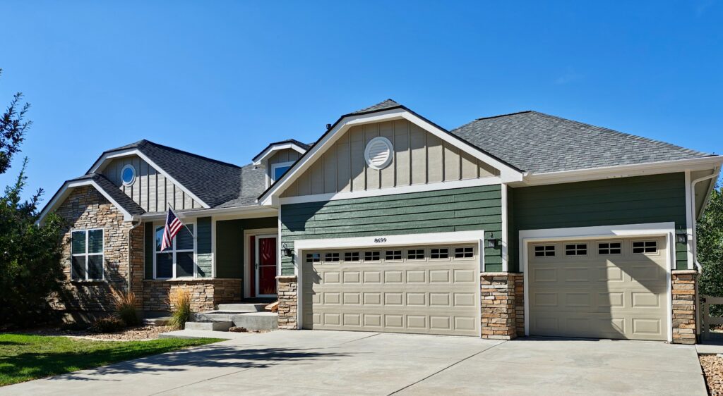 Board and batten gables painted Sherwin-Williams Taupe Tone (SW 7633) above Sherwin-Williams Rosemary (SW 6187) siding, sunny lot, Colorado