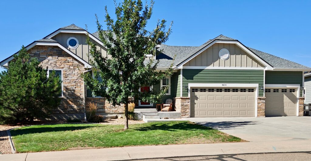 Siding painted Sherwin-Williams Rosemary (SW 6187) beside warm stone on a suburban house, sunny lot, Colorado