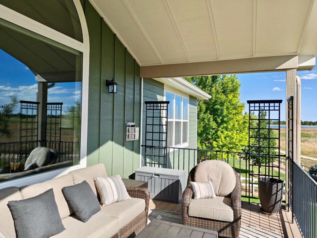 A porch with Sherwin-Williams Egret White ceiling and Sherwin-Williams Rosemary board and batten siding.