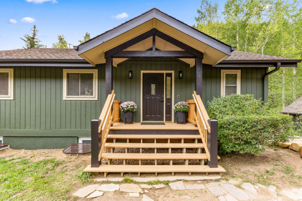 Front view of mountain home painted with SW Laurel Woods, Universal Khaki, and Black Magic