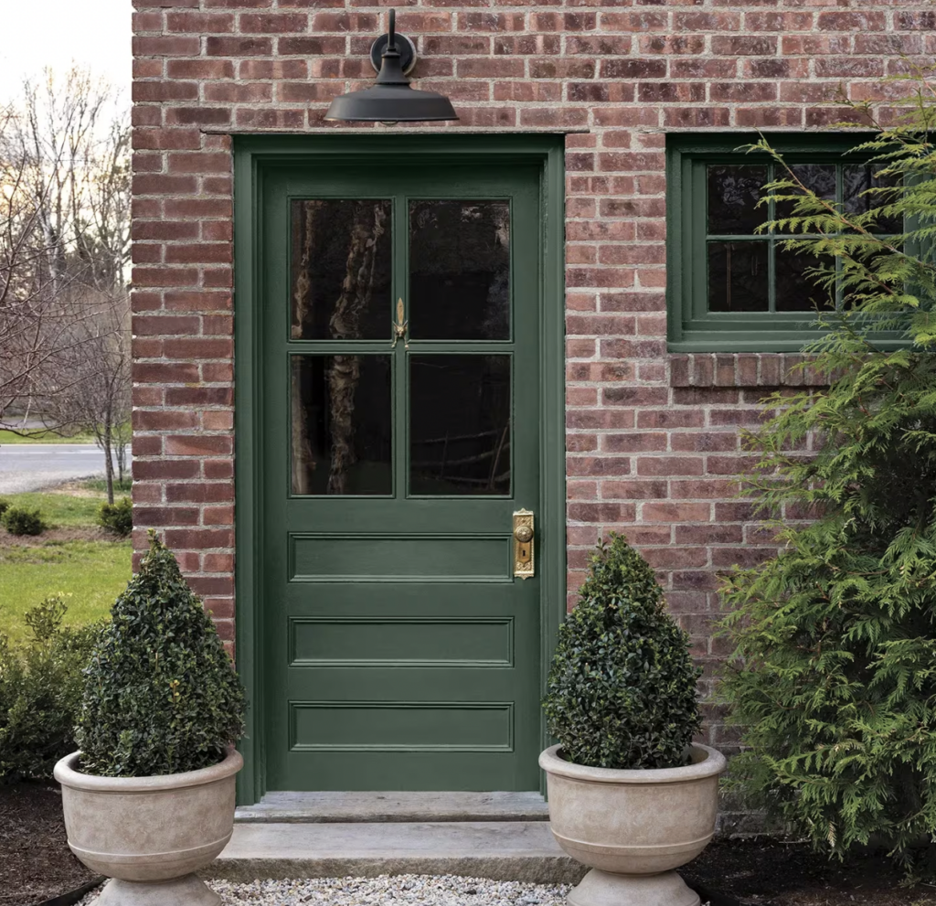 A Benjamin Moore Webster Green front door on a brick house.